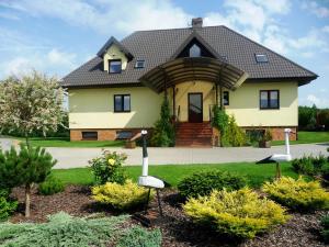 a large yellow house with a black roof at Nad Zatoką in Bryzgiel