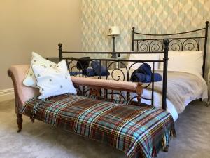 a bedroom with a bed and a bench with pillows at Brookfield House Warcop in Warcop