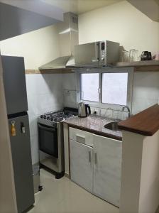 a small kitchen with a stove and a sink at Lavalleja 71 II in Mercedes