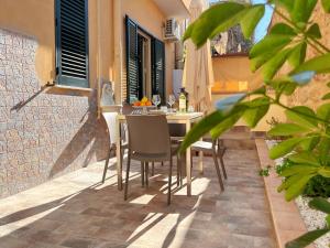 un patio con mesa y sillas en un edificio en Solemar Sicilia - Casa Valguarnera, en Bagheria