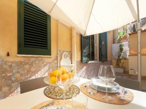 una mesa con dos vasos y un bol de fruta en Solemar Sicilia - Casa Valguarnera, en Bagheria