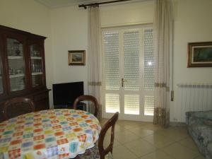 sala de estar con mesa y ventana con persianas en Viareggio all seasons en Viareggio