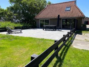 a house with a fence and a table and benches at Ballumerhoeve t Pandje in Ballum
