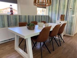 una mesa de comedor blanca y sillas en una habitación en Ballumerhoeve t Pandje en Ballum
