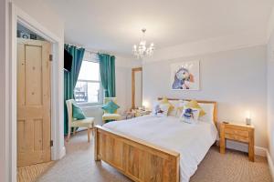a bedroom with a large bed and a chandelier at White Rose Guest House in Filey