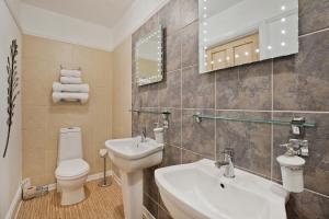 a bathroom with a sink and a toilet and a mirror at White Rose Guest House in Filey