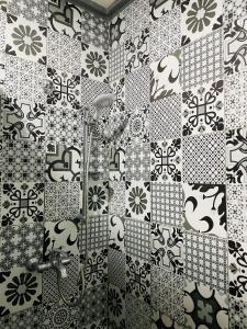 a bathroom with black and white tiles on the wall at Hiking Nomads Guesthouse in Tamellalt