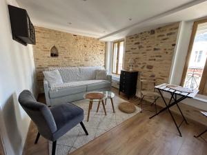 een woonkamer met een bank en een tv bij Meublé de tourisme, Les chambres du Beffroi in Boulogne-sur-Mer