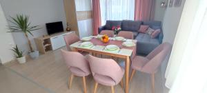 een woonkamer met een tafel en stoelen en een bank bij Forest Apartments in Bitola