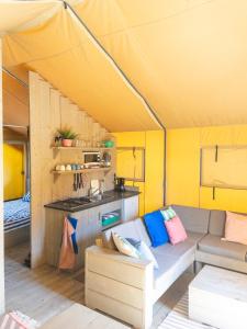a living room with a couch in a tent at Glamping tent with bathroom - Tuscany next to sea! in Viareggio