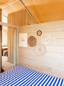 維亞雷焦的住宿－Glamping tent with bathroom - Tuscany next to sea!，卧室设有1张带蓝色和白色床的墙壁