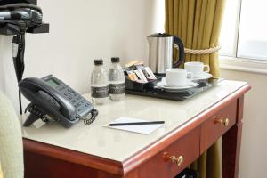 uma secretária com um telefone em cima de um quarto em The Prime London Hotel em Londres