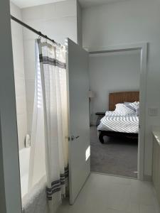 a bathroom with a door leading to a bedroom with a bed at 3 Story Luxury Apt Las Olas FTL in Fort Lauderdale