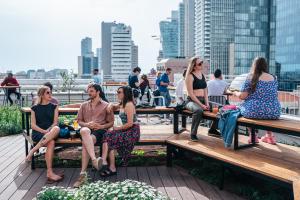 a group of people sitting on benches in a city at Abraham Tel Aviv in Tel Aviv