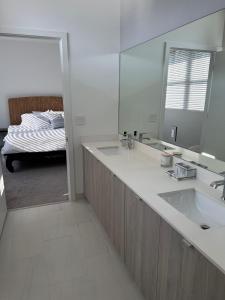 a bathroom with a sink and a mirror and a bed at 3 Story Luxury Apt Las Olas FTL in Fort Lauderdale