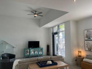 a living room with a couch and a ceiling fan at 3 Story Luxury Apt Las Olas FTL in Fort Lauderdale