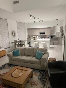 a living room with a couch and a table and a kitchen at 3 Story Luxury Apt Las Olas FTL in Fort Lauderdale
