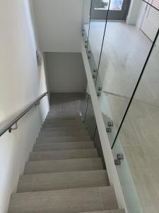 a staircase with a glass railing and a stair case at 3 Story Luxury Apt Las Olas FTL in Fort Lauderdale