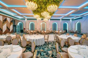 a ballroom with tables and chairs and chandeliers at PRESTIGE PLAZA in Suceava