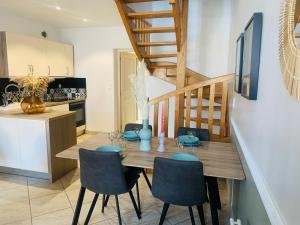 a kitchen and dining room with a wooden table and chairs at La roseraie de L arguenon, appartement charmant centre ville in Jugon Les Lacs
