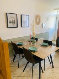comedor con mesa de madera y sillas en La roseraie de L arguenon, appartement charmant centre ville, en Jugon Les Lacs