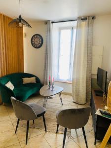 sala de estar con sofá, mesa y sillas en La roseraie de L arguenon, appartement charmant centre ville, en Jugon Les Lacs