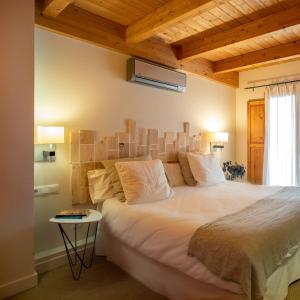 a bedroom with a large bed with a wooden ceiling at Hotel Boutique Niu de Sol - Designed for Adults in Palau-Saverdera