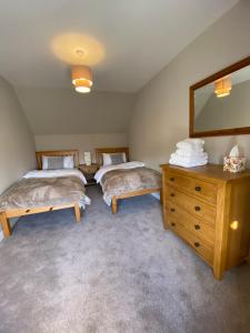 um quarto com 2 camas, uma cómoda e um espelho em Croft@42 em Vatsker