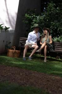 a man and woman sitting on a park bench at Enchanting Retreat - The English Cottage at Tamborine Mountain in Mount Tamborine