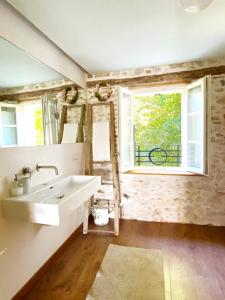 een badkamer met een wastafel en 2 ramen bij Casa delle Arti Fattoria dei fiori in Sospirolo