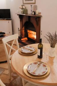 a table with two plates and a bottle of wine at The Romantic Pink English Cottage at Tamborine Mountain in Mount Tamborine