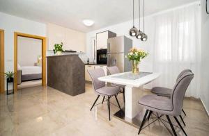 una cucina e una sala da pranzo con tavolo e sedie di Seafront 2-bedroom apartment Nika - Rabac a Rabac