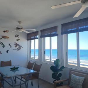 a dining room with a table and chairs and the ocean at Agua Marina in Arenales del Sol