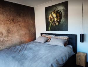 sypialnia z łóżkiem z obrazem kwiatowym na ścianie w obiekcie Our House w mieście Breskens