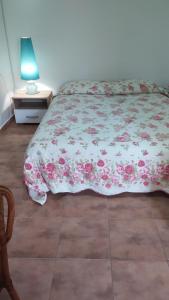 a bedroom with a bed with a floral comforter at Sweet home with a jard Slavica in Šušanj