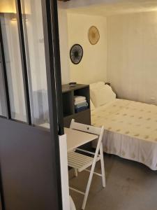 a small room with a bed and a chair at LA GRENILLE in Antibes