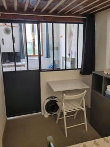 a room with a desk and a chair and windows at LA GRENILLE in Antibes