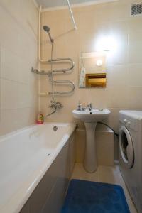 a bathroom with a sink and a washing machine at Nadezhda Apartments in Samal in Almaty
