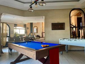 a pool table in a living room with a pool at Aux Moules de Harhoura Rabat in El Harhoura