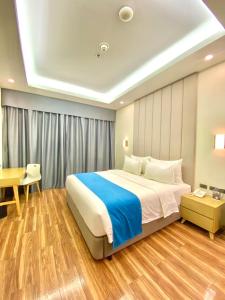 a bedroom with a large bed and a desk at Bravo Tanauan Hotel in Tanauan
