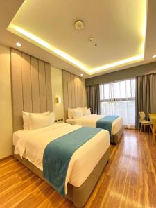 een hotelkamer met 2 bedden en een tafel bij Bravo Tanauan Hotel in Tanauan