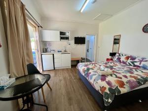 um quarto com uma cama, uma mesa e uma cozinha em Cootamundra Caravan Park em Cootamundra