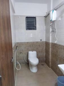 a bathroom with a toilet and a phone on the wall at Seapoint(Seascape) in Dapoli