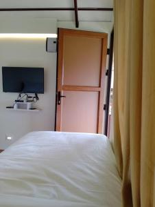 a bedroom with a bed and a door with a television at CHEENI HILL RESORTS in Kanthalloor