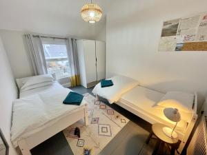 a bedroom with two beds and a table and a window at Ty Capel Vestry in Conwy