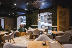 un restaurante con mesas, sillas y una pared en SH Ingles Boutique Hotel en Valencia