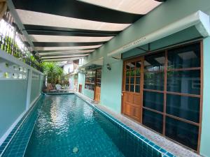 a swimming pool in front of a house with a building at T-House BKK 2Floors near BTS with swimming pool and free Wifi in Khlong Toei