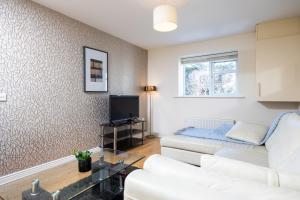 uma sala de estar com um sofá branco e uma televisão em Errigal House, Eglington Road, Donnybrook, Dublin 4 -By Resify em Dublin