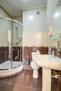 ein Bad mit einem WC, einem Waschbecken und einer Dusche in der Unterkunft Hotel Touristan Bishkek in Bischkek