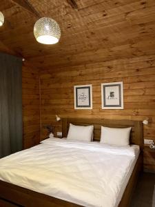 a bedroom with a large bed with wooden walls at Boro Club in Kachaly